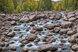Stock Photo of River water long exposure,rocks on the nature trees backdrop