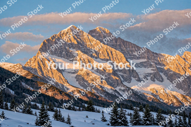 Stock Photo of Large mountain at sunset accompanied by a forest on the slope