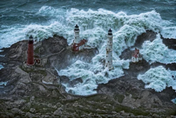 Lighthouses in the rocks and storm ocean sea
