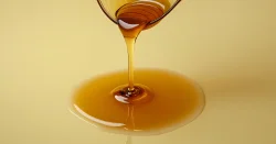 Stock Photo of honey dripping from a wooden dipper